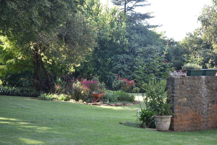 The lawn sweeping past a stone pillar and garden beds at Craffenheim Rottweilers