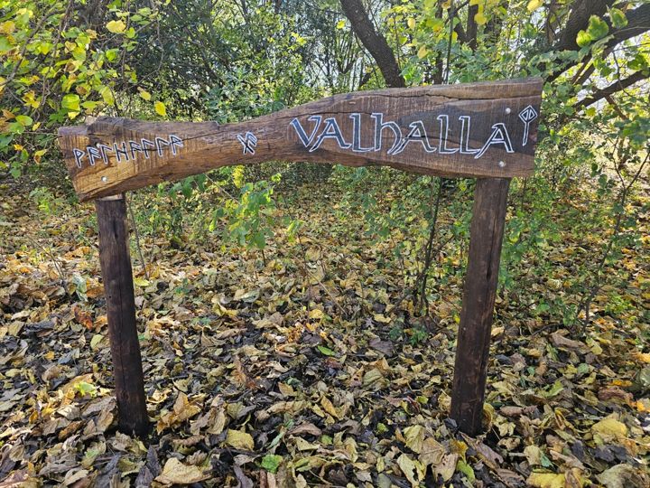 The Valhalla sign among autumn leaves beneath the trees